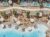 A luxury beach resort with pools and loungers.