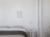 Minimalist bedroom features a bed, art, and a small table.